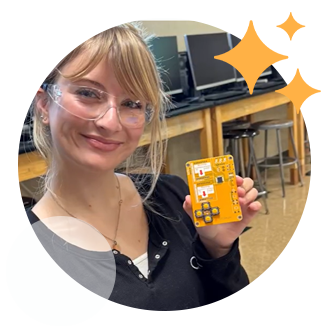 Close-up of a high school student smiling with a circuit board in a hands-on manufacturing lab, surrounded by decorative star accents.